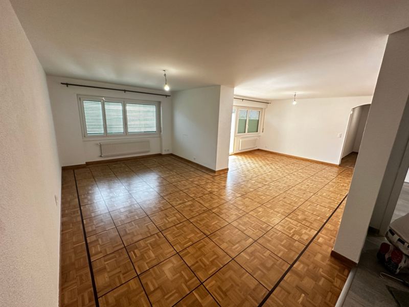 Salon rénové, murs blancs et parquet
